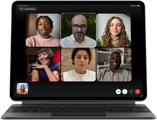 Černý iPad Air připojený k Magic Keyboardu, na obrazovce probíhá skupinový hovor přes FaceTime